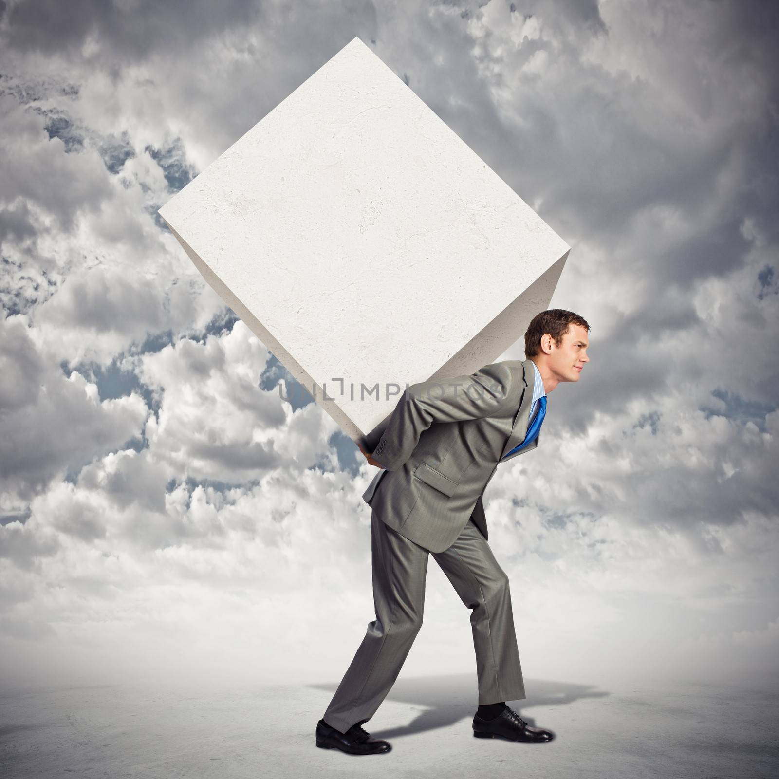 Image of businessman carrying big white cube on his back