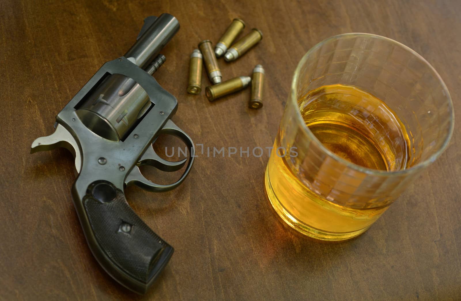 deadly combination of alcohol and firearms on wood background