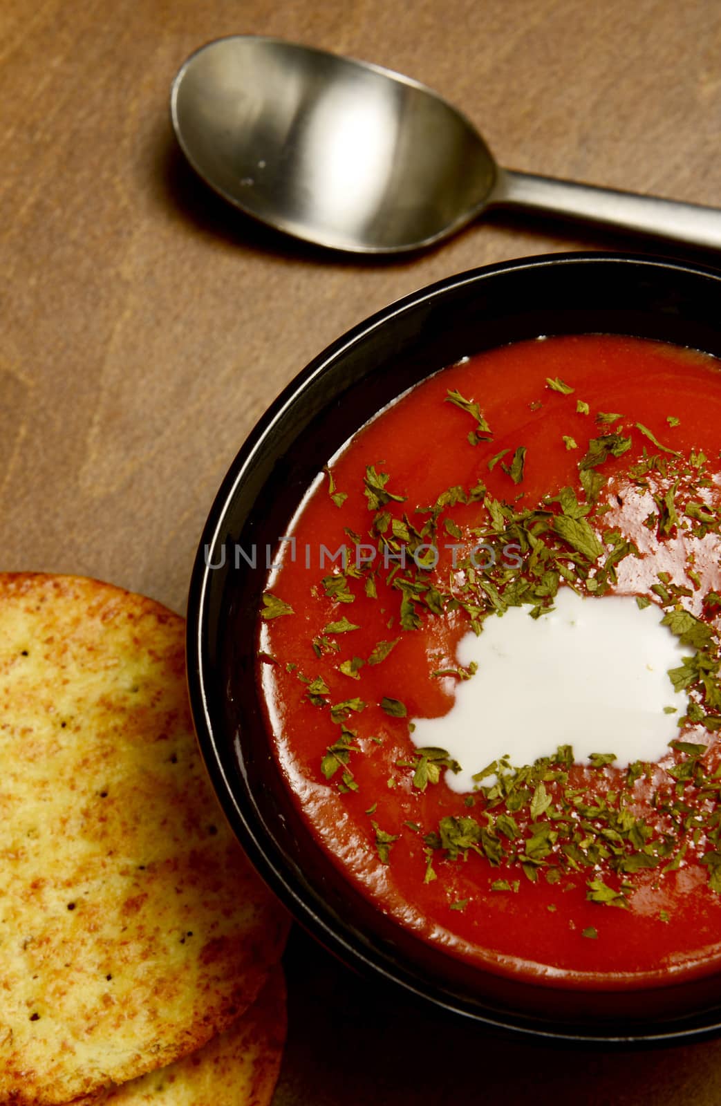creamy tomato soup on a dark wooden table by ftlaudgirl