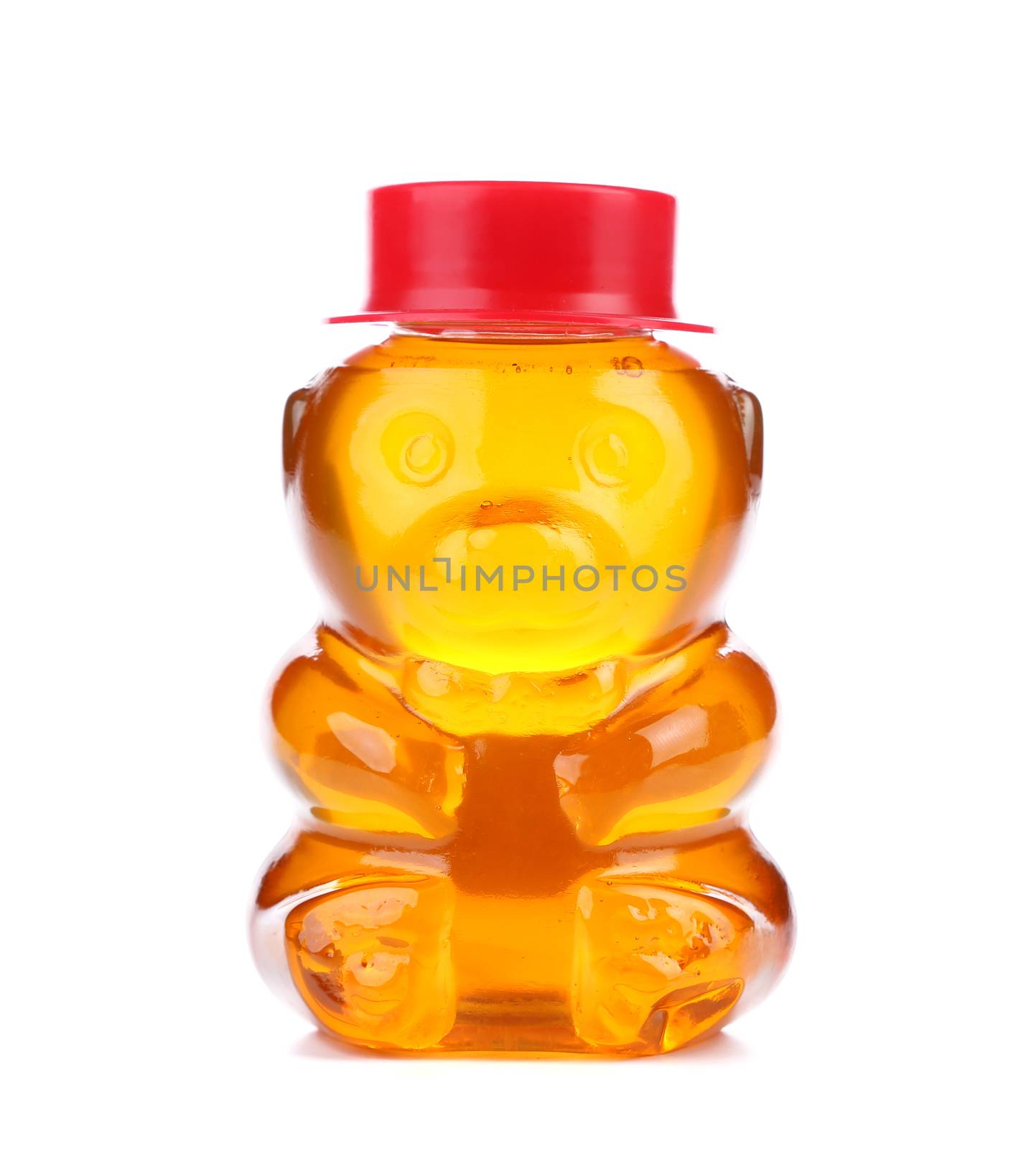 Bottle shaped like a bear and filled with honey. White background.