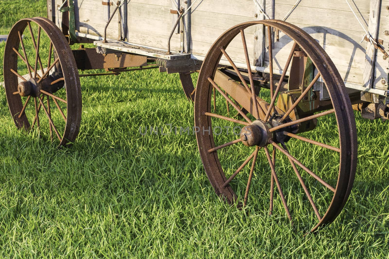 Side view of 2 metal wagon wheels from an old stagecoach from the 1800s.