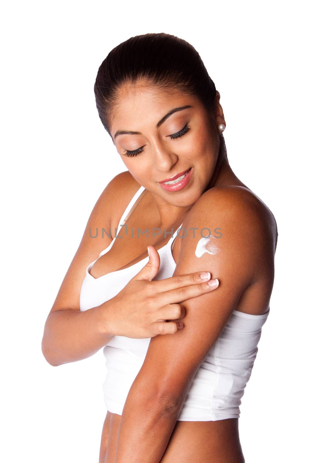 Beautiful happy smiling woman applying exfoliating moisturizing lotion cream on arm, bodycare skincare concept.