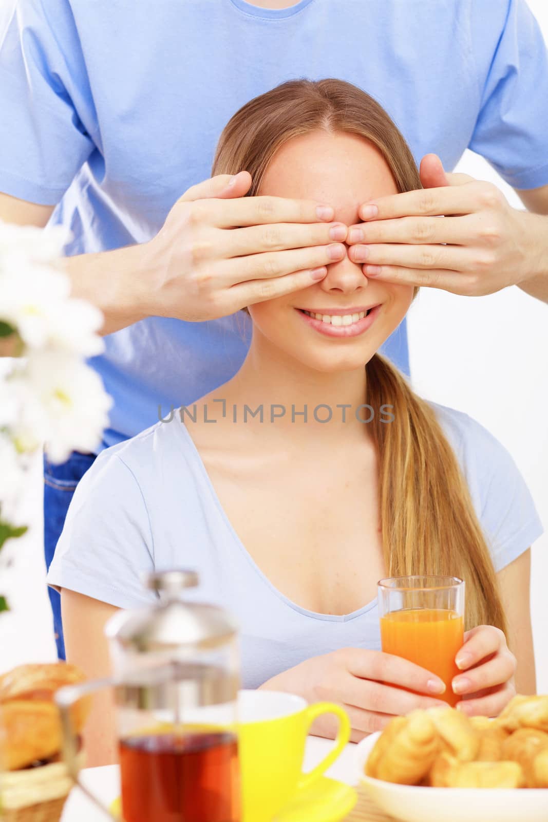 Young couple at home together - closing partner's eyes