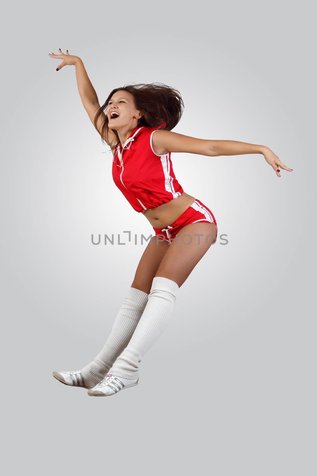 Young female dancer jumping against white background