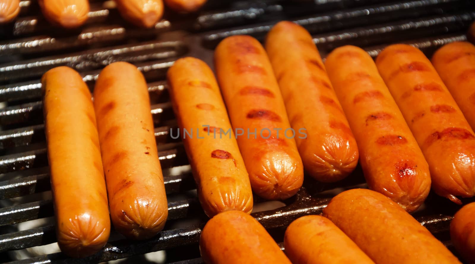 Sausages preparing on grill in summer day