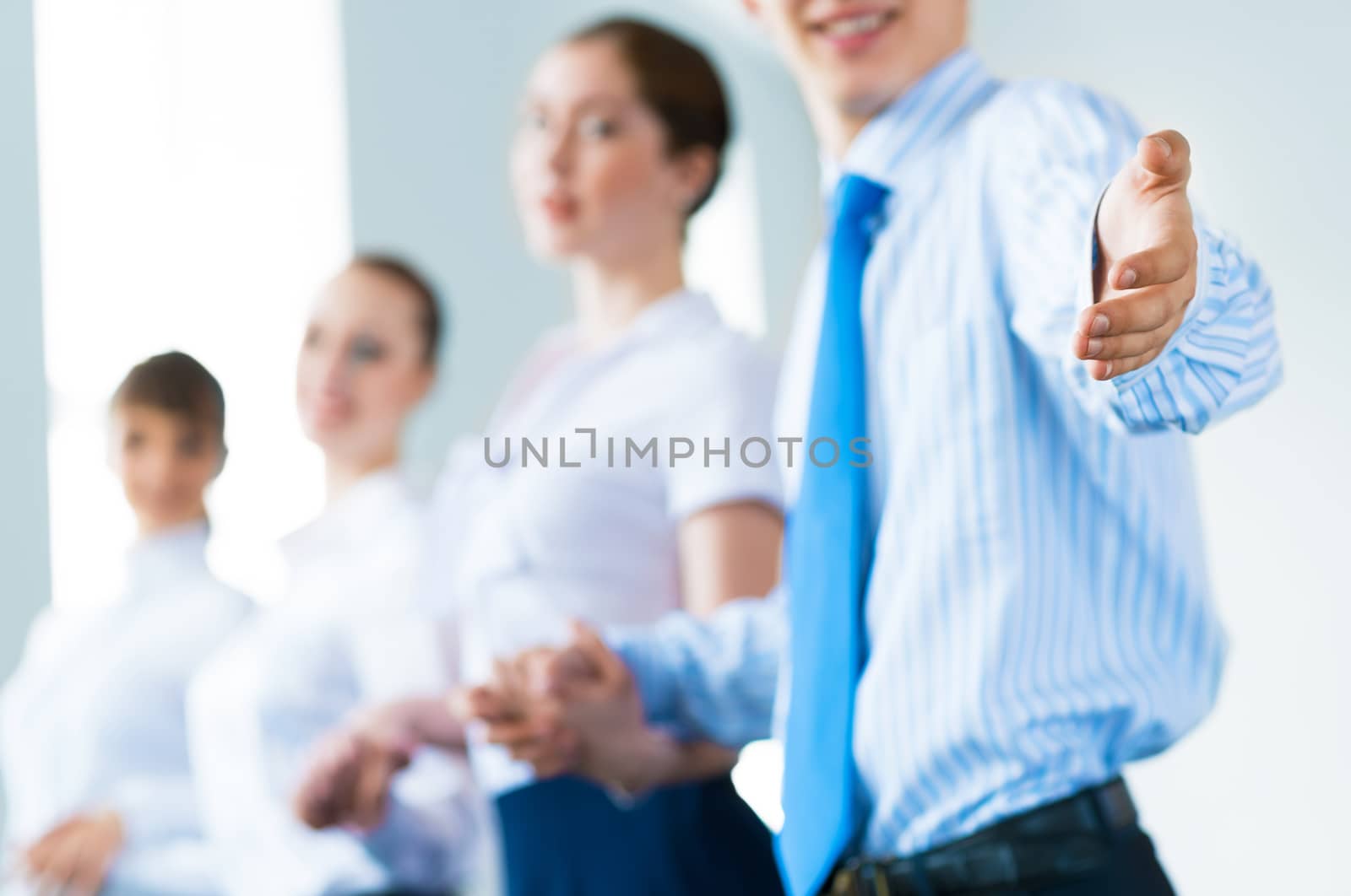 invitation to the team, the business man stretches out his hand, behind him a number of young businessmen