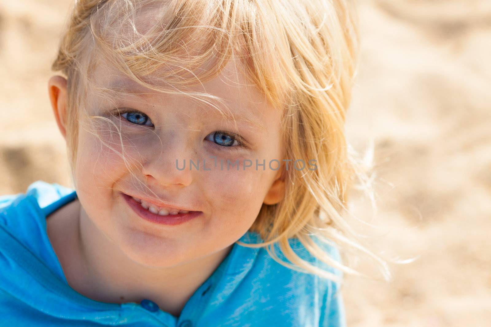 Close-up portrait of a cute smiling boy playing outdoors.