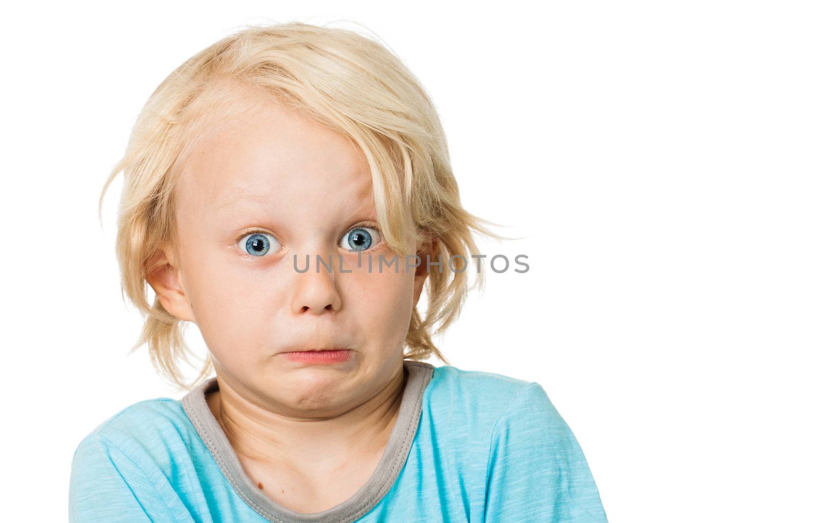 A cute funny boy pulling funny scared face. Isolated on white.