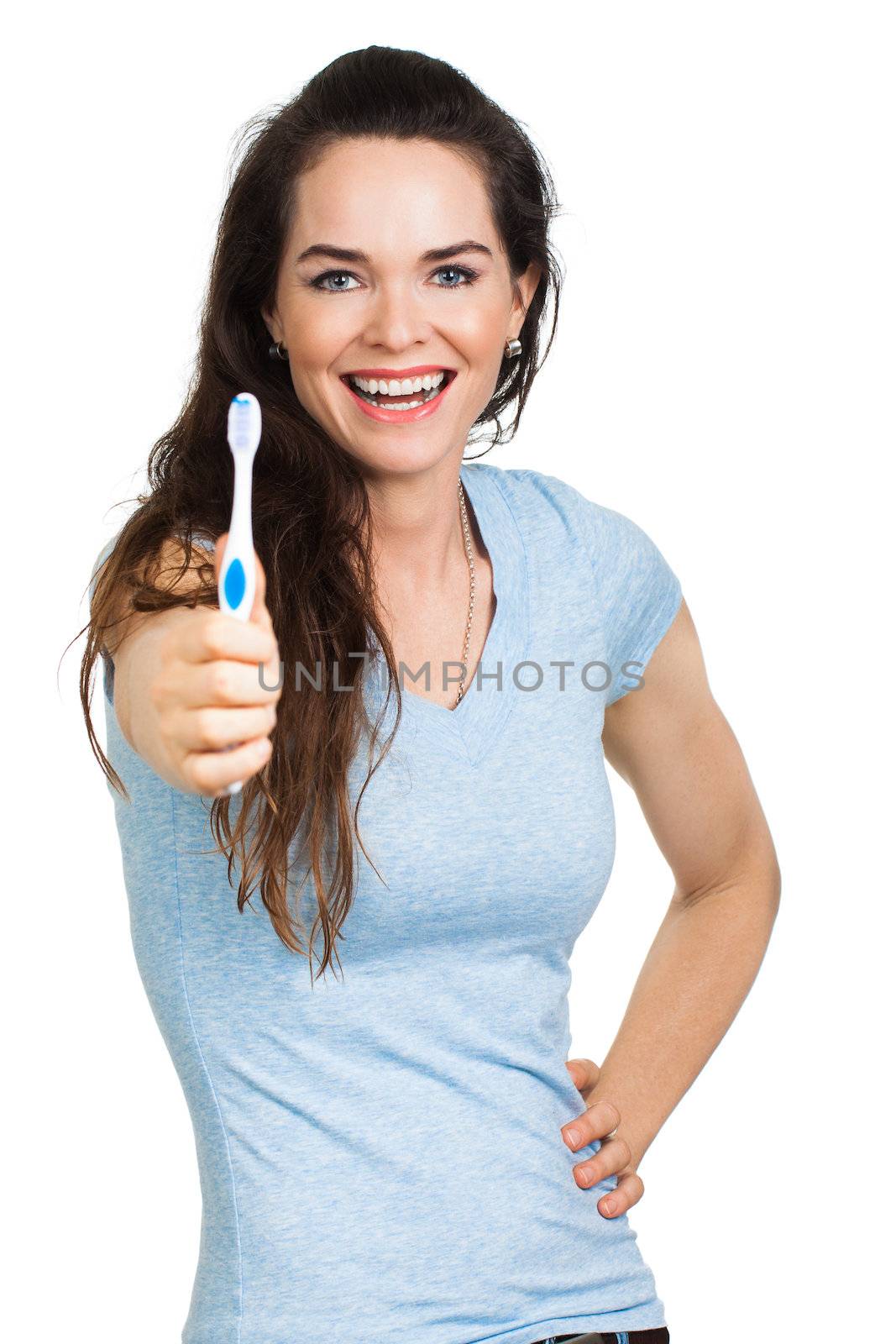 A happy beautiful woman with perfect teeth holding out a toothbrush. Isolated on white.