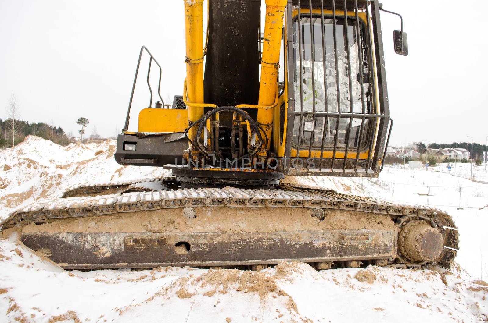 closeup of caterpillar excavator tractor driver cabin covered with snow in winter. heavy machinery industry.