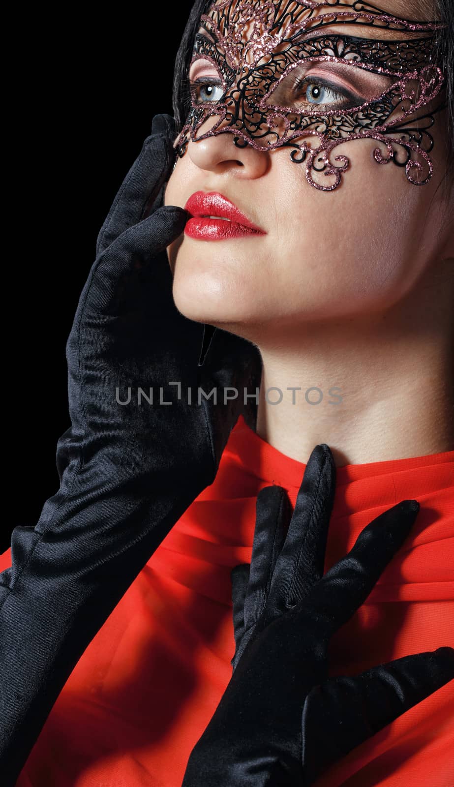 Girl in a Venetian masquerade mask isolated on a black background