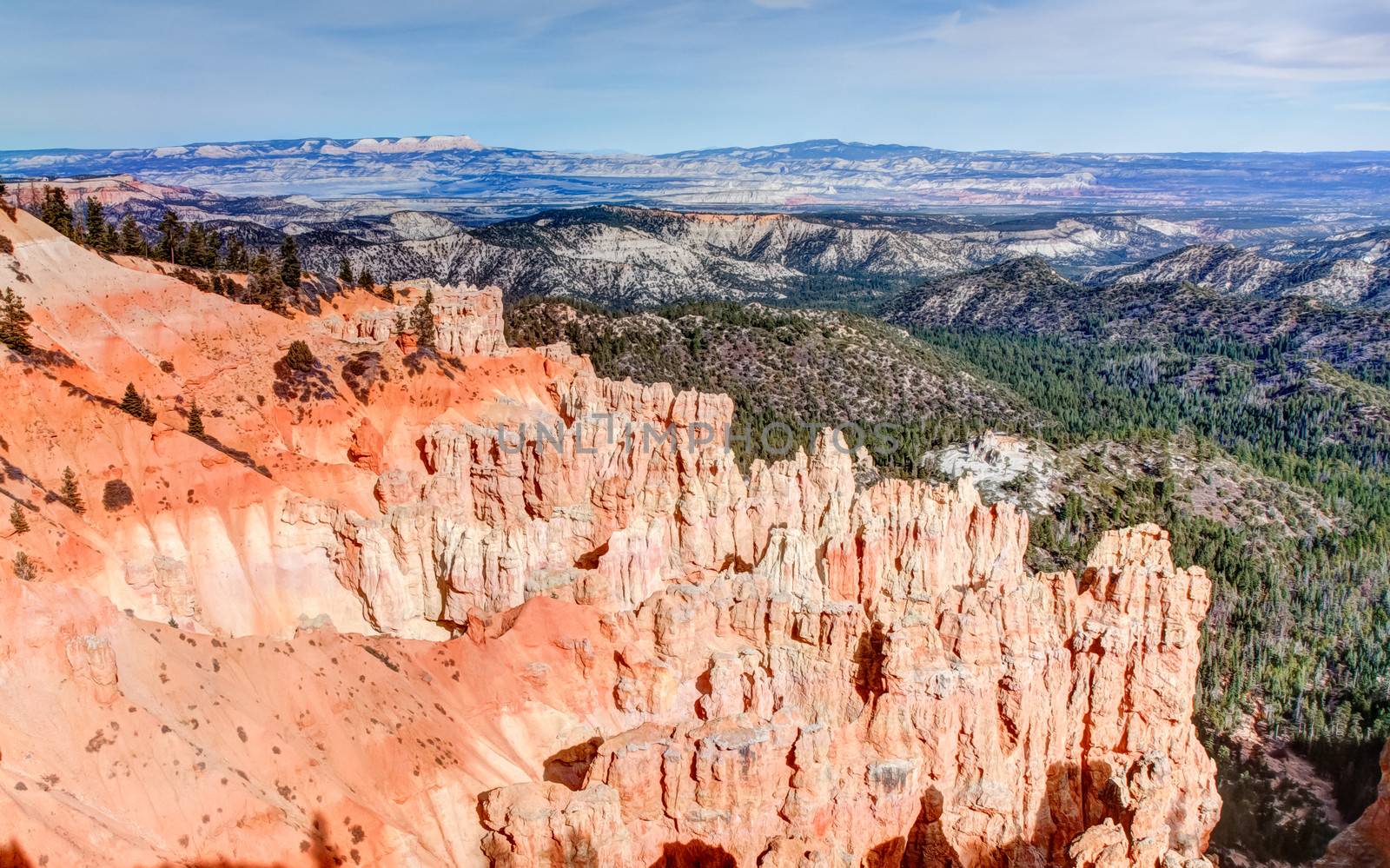 Ponderosa Point, at Bryce Canyon National Park, is one of the several natural amphitheaters carved out of eastern edge of the Paunsaugunt Plateau. The striking red colors against the green valley and mountainous backdrop combine for an exciting image.