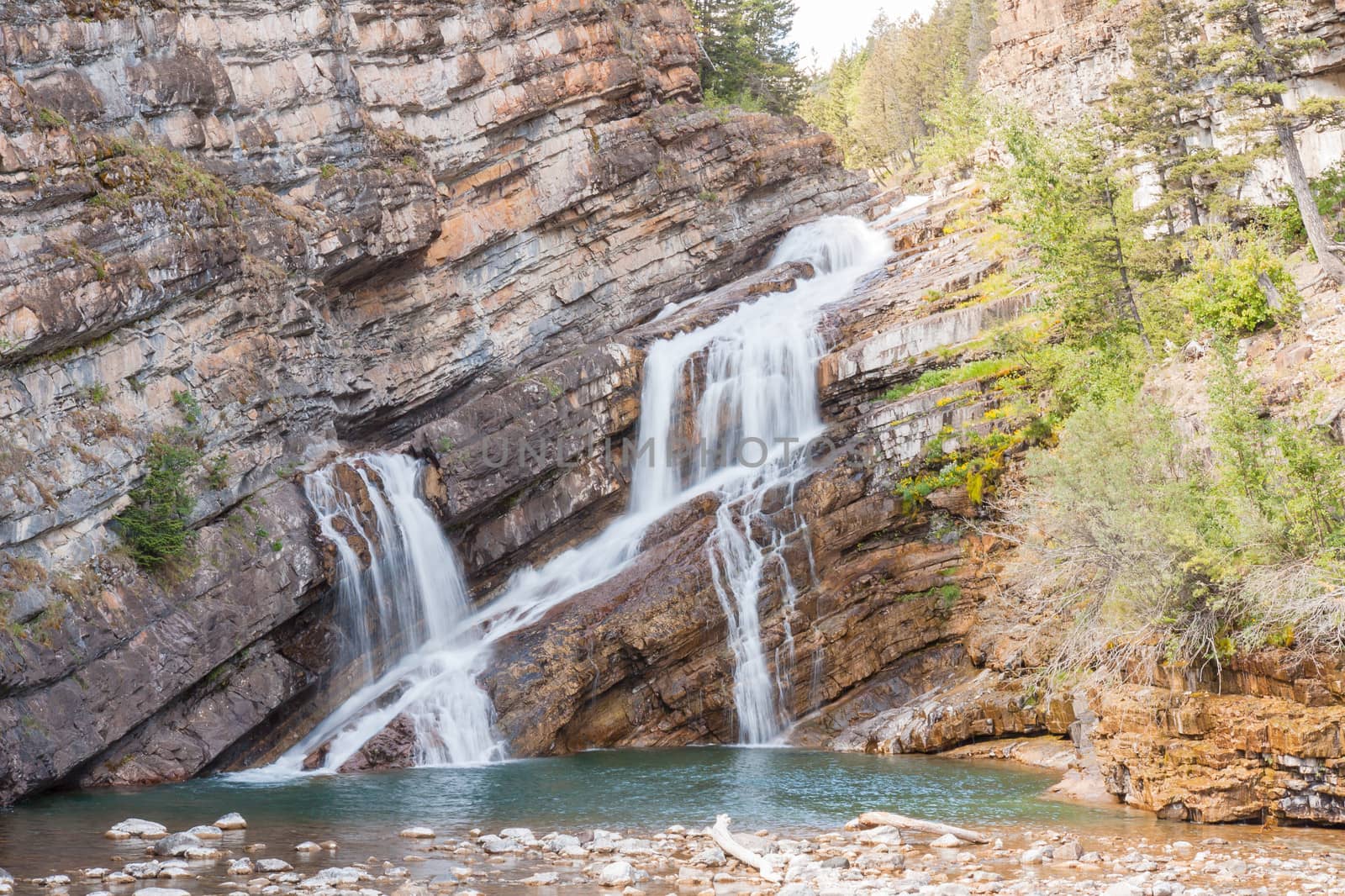 This is Cameron Falls in Waterton Townsite next to Waterton National Park, Canada. The slope of the rocks and the channel the water flows through results in a unique looking waterfall.