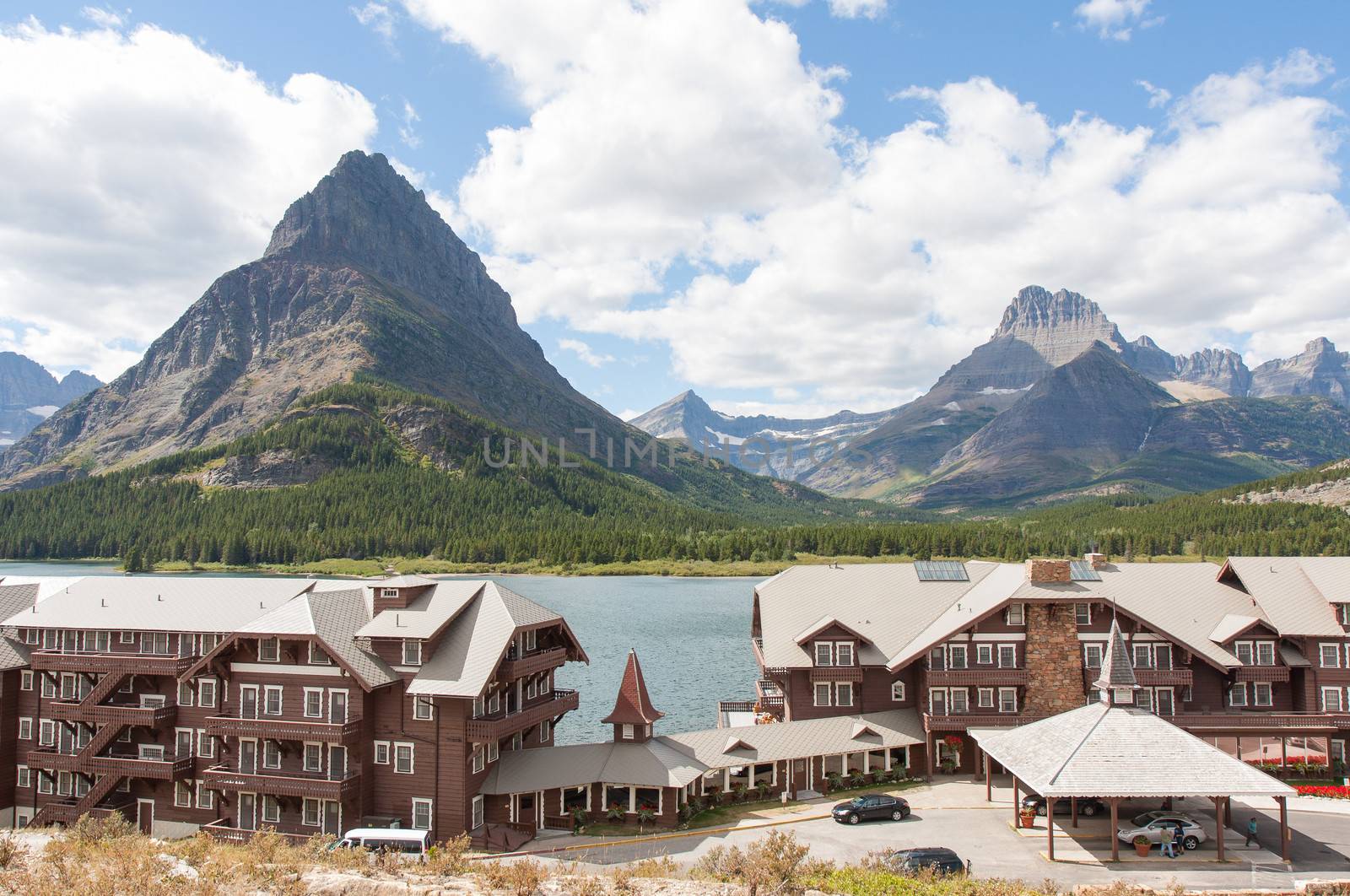 Opening in July 1915, the Many Glacier Hotel is a famous historic hotel in Glacier National Park. Located beside the Swiftcurrent Lake, it has fabulous views of mountain peaks on the continental divide. Grinnell Point is seen directly behind the hotel.
