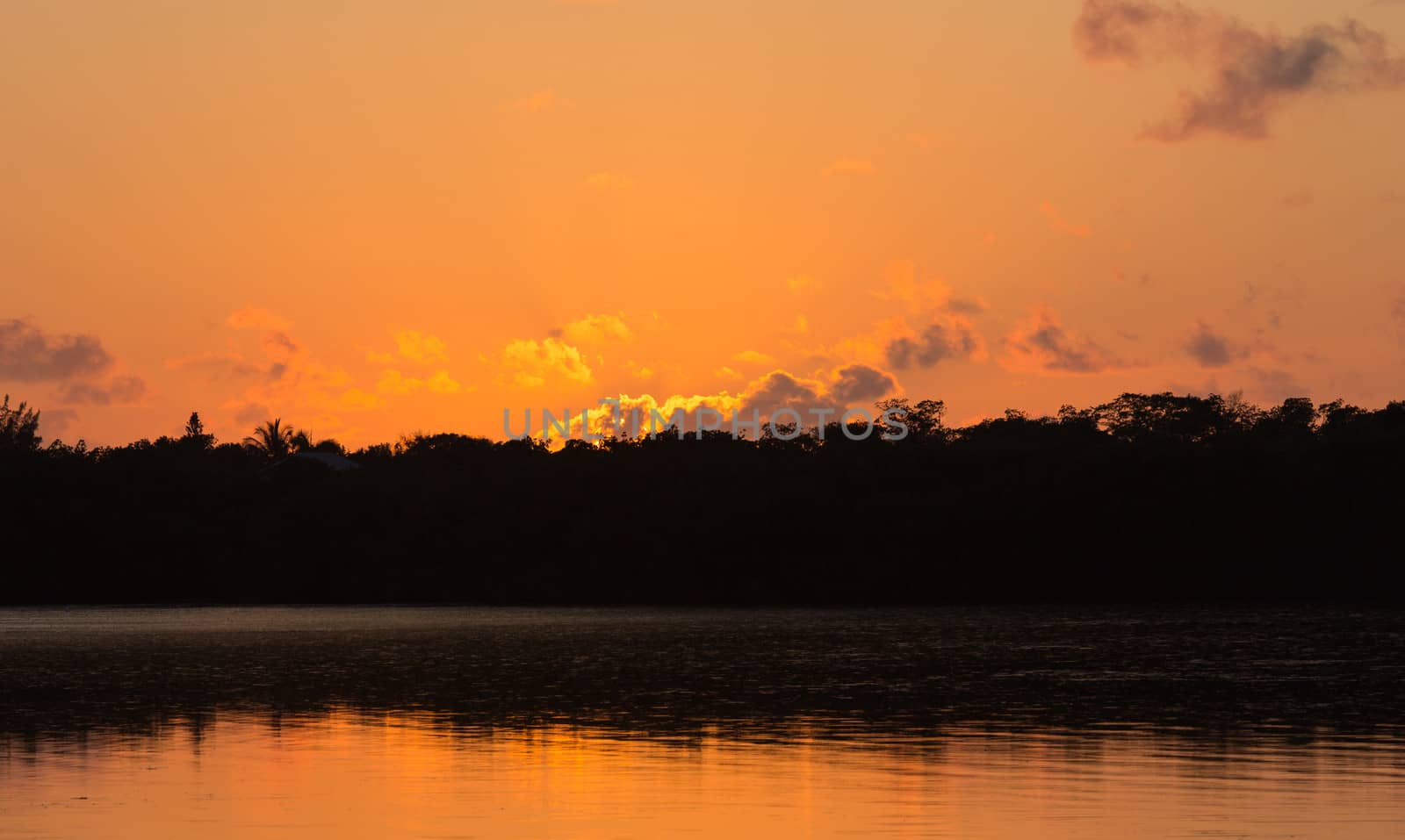 We witnessed a beautiful sunset at Marathon Key in the Florida Keys. As the sunlight attempts to pierce the low lying clouds an incredible orange glow takes hold. 