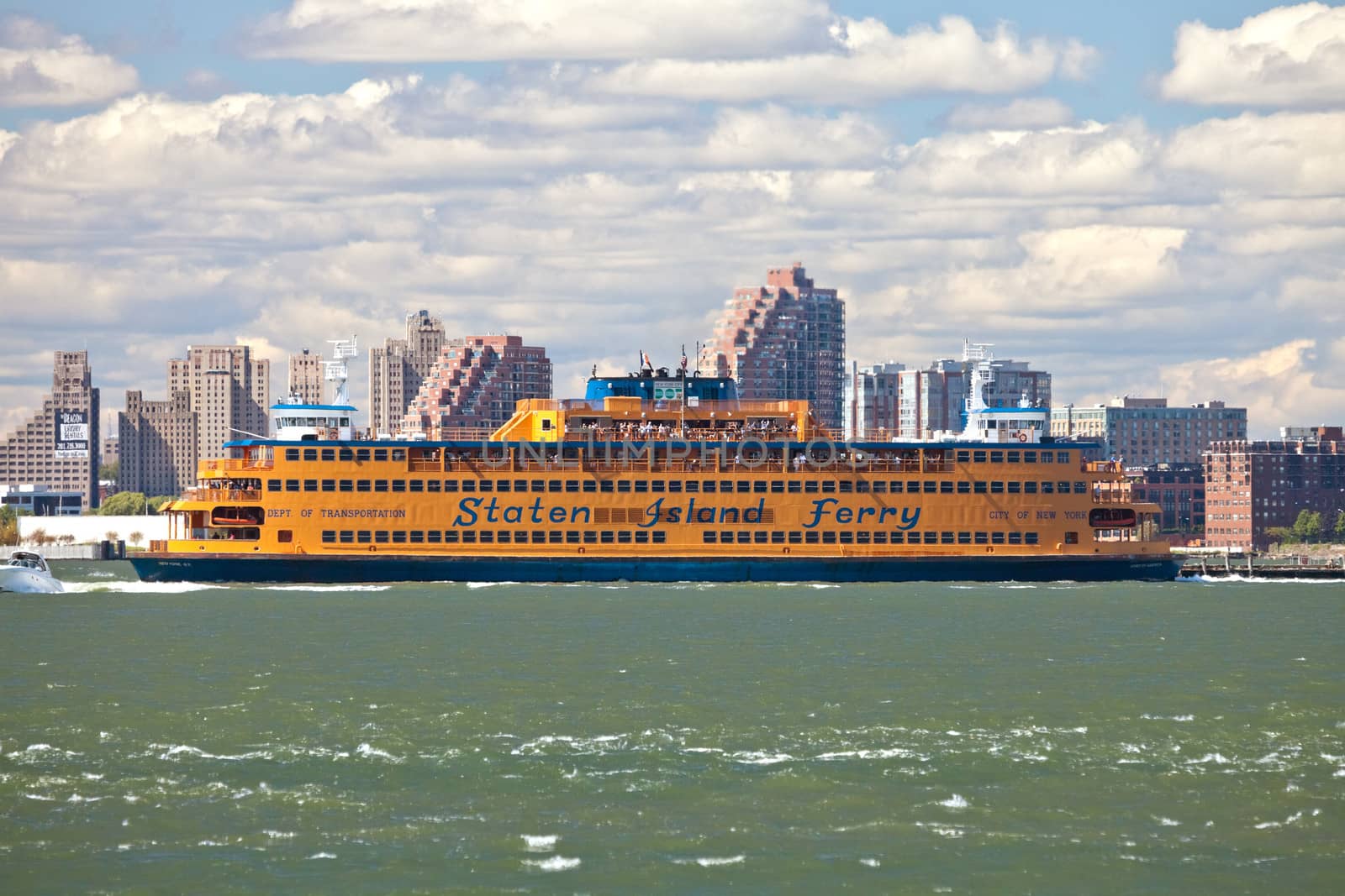 NEW YORK - SEPTEMBER 23: The massive Staten Island Ferry departs from Battery Park in New York City on September 23, 2012. It is a free rides that offers great views of the skyline, and also carries cars.