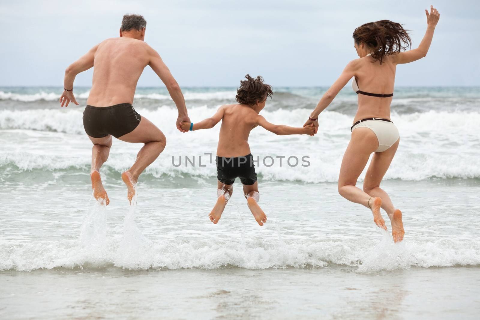 happy family ith two boys having fun in water summer holiday by juniart