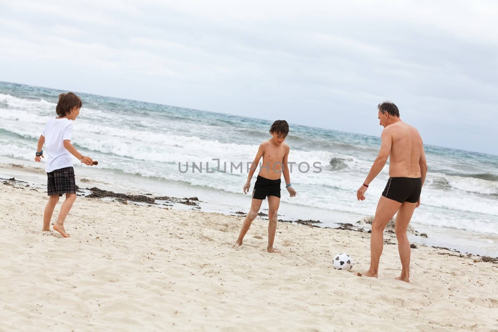 happy family father two kids playing football on beach summer fun soccer