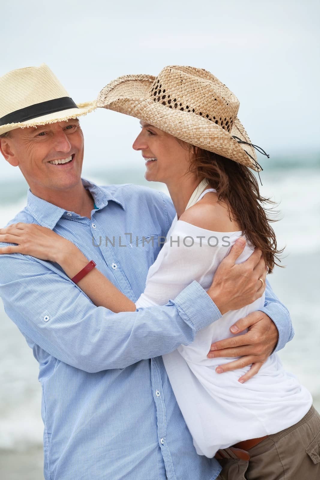 happy adult couple in summertime on beach having fun vacation