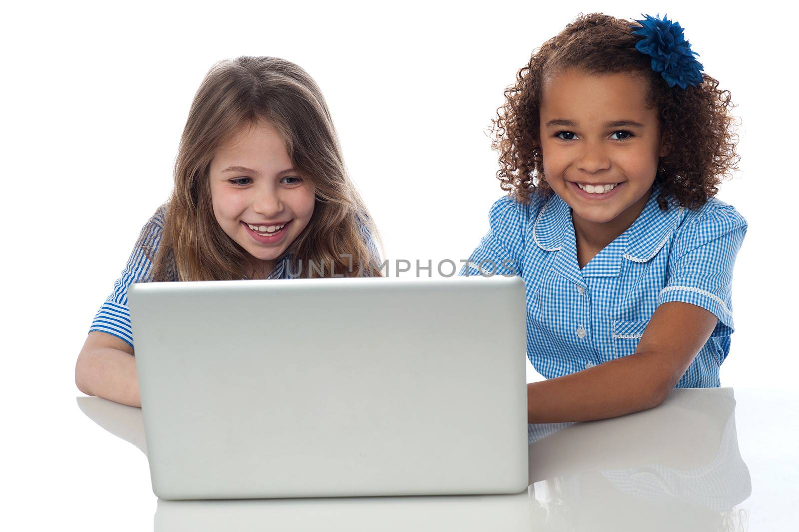 Exceited school girls with laptop by stockyimages