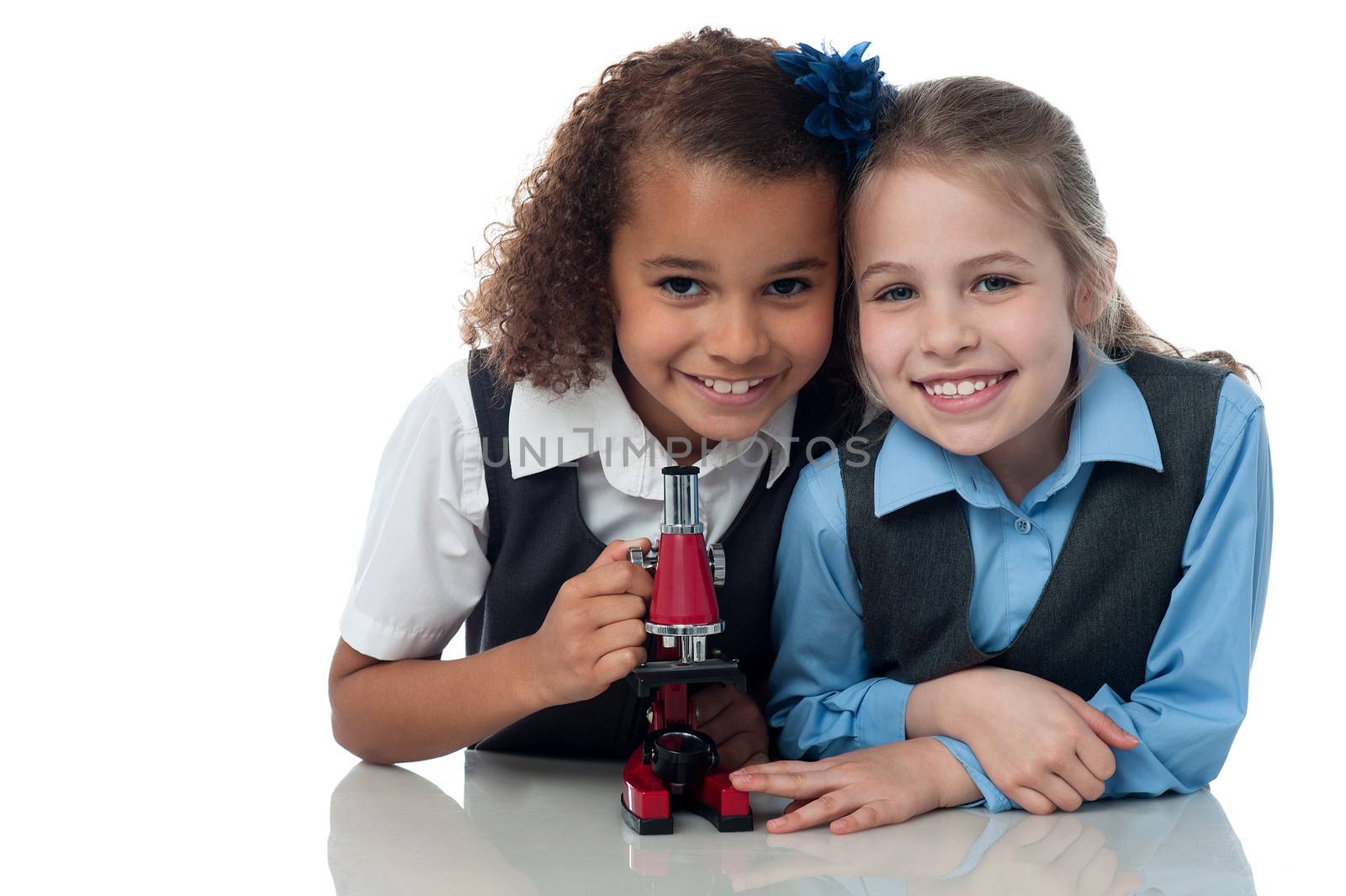 School girls using microscope in science lab