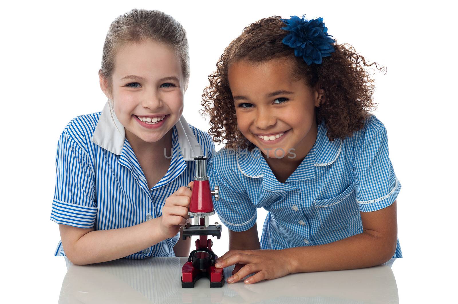 Kids in uniform playing with microscope by stockyimages
