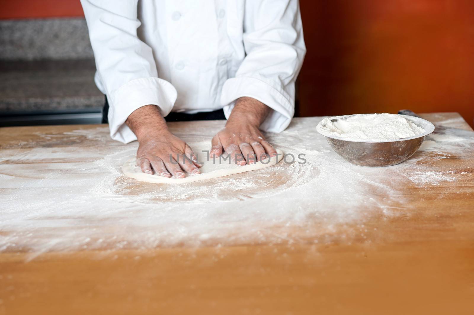 Baker preparing pizza base