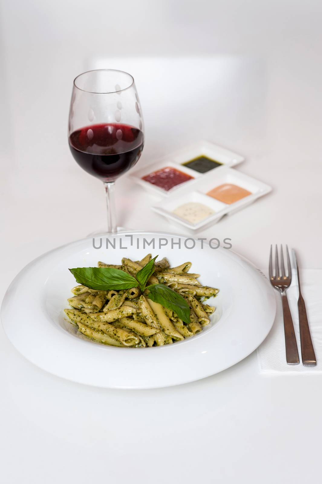 Yummy pasta served with red wine by stockyimages