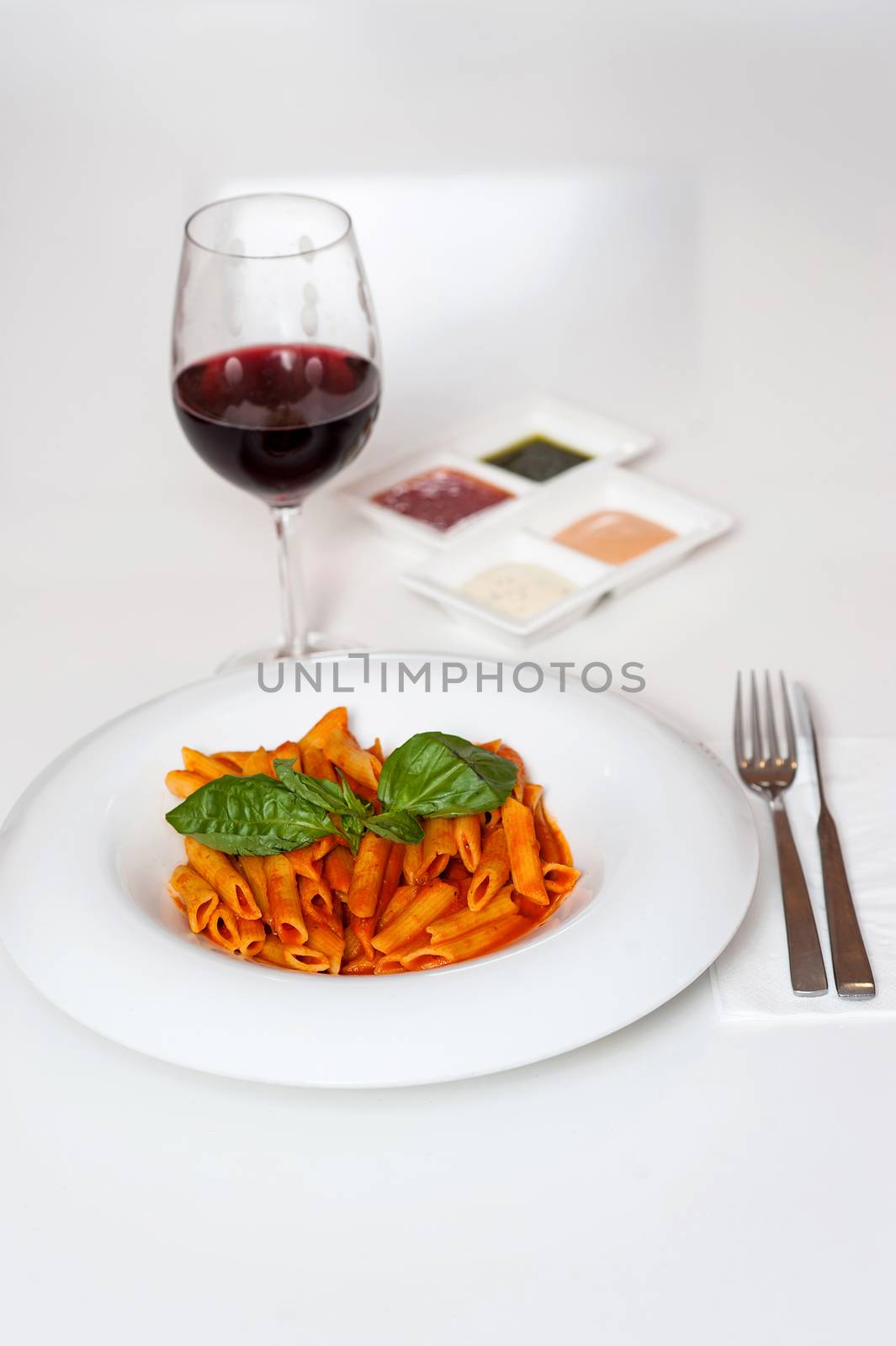 Yummy pasta served with sauces and red wine
