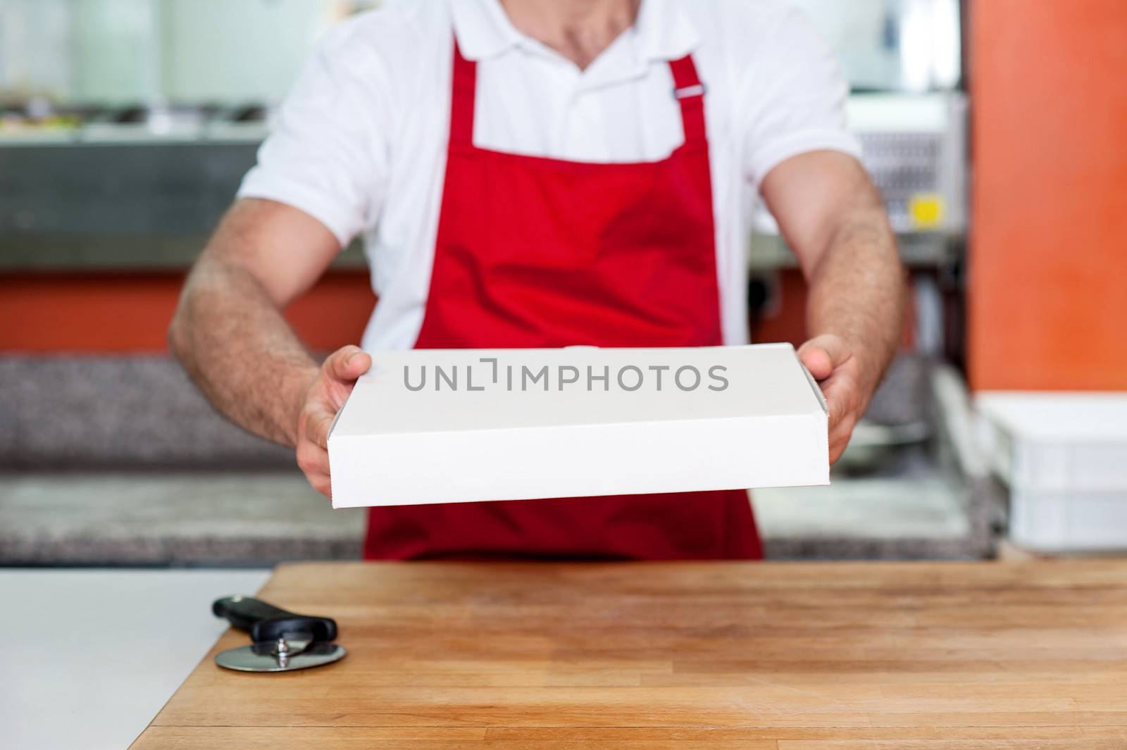 Chef handing over pizza, cropped image.