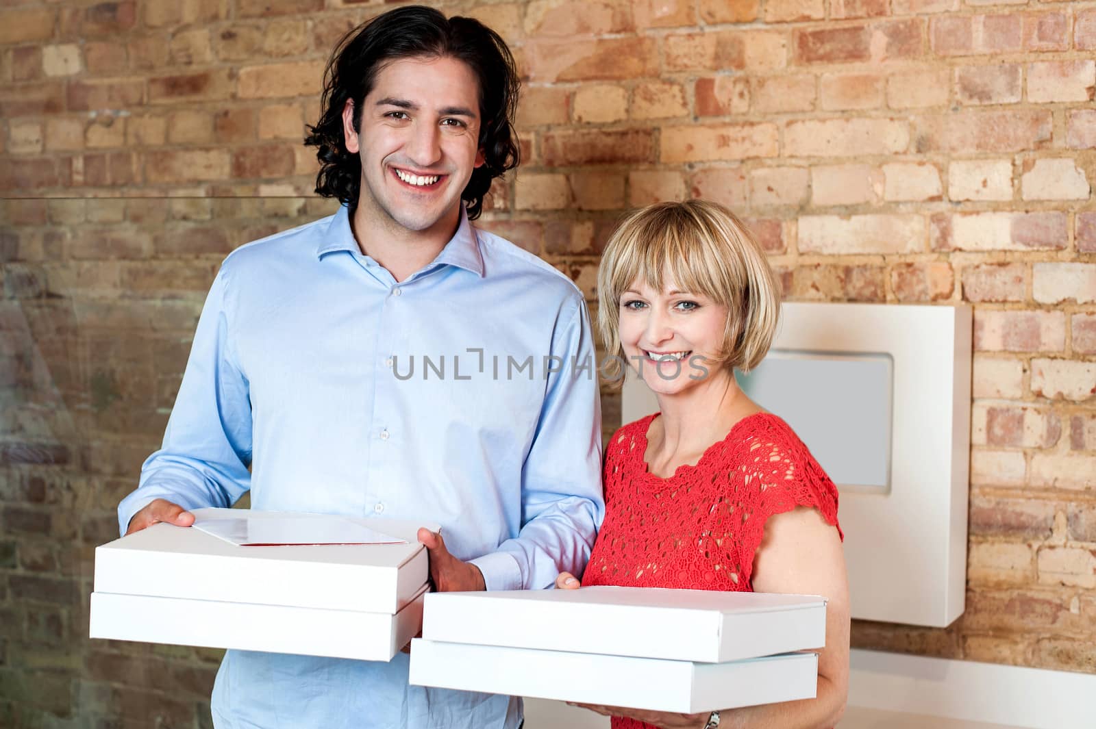 Happy young couple with pizza boxes by stockyimages