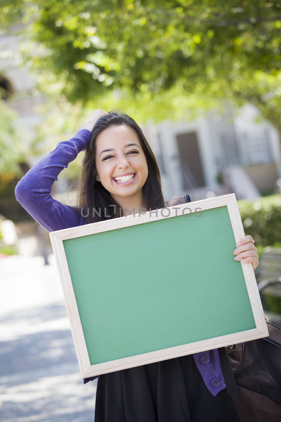 Excited Mixed Race Female Student Holding Blank Chalkboard by Feverpitched