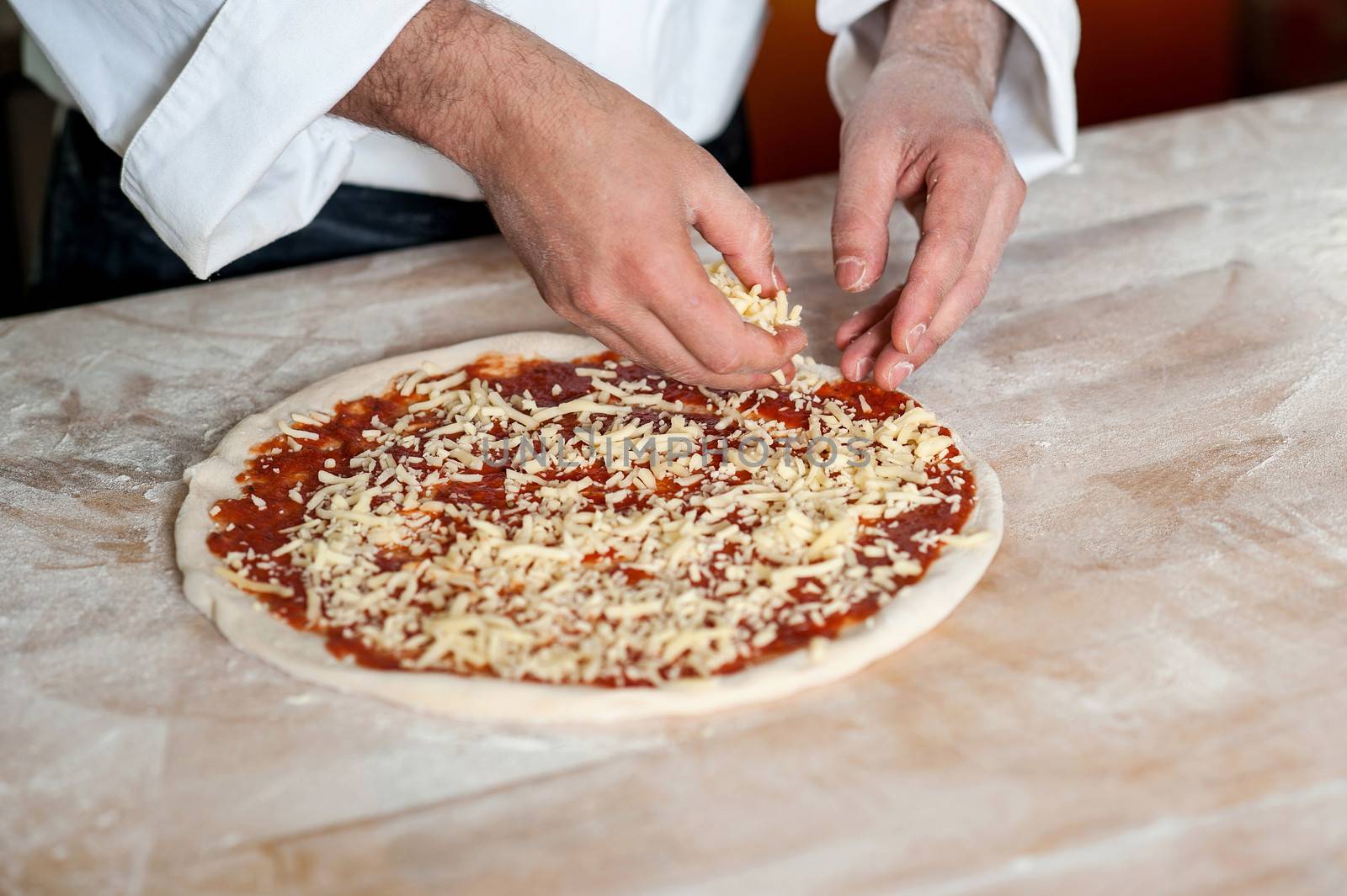 Male chef preparing pizza, closeup shot by stockyimages