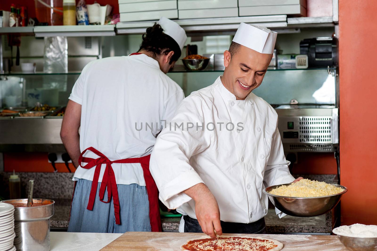 Expert chefs at work inside restaurant kitchen by stockyimages