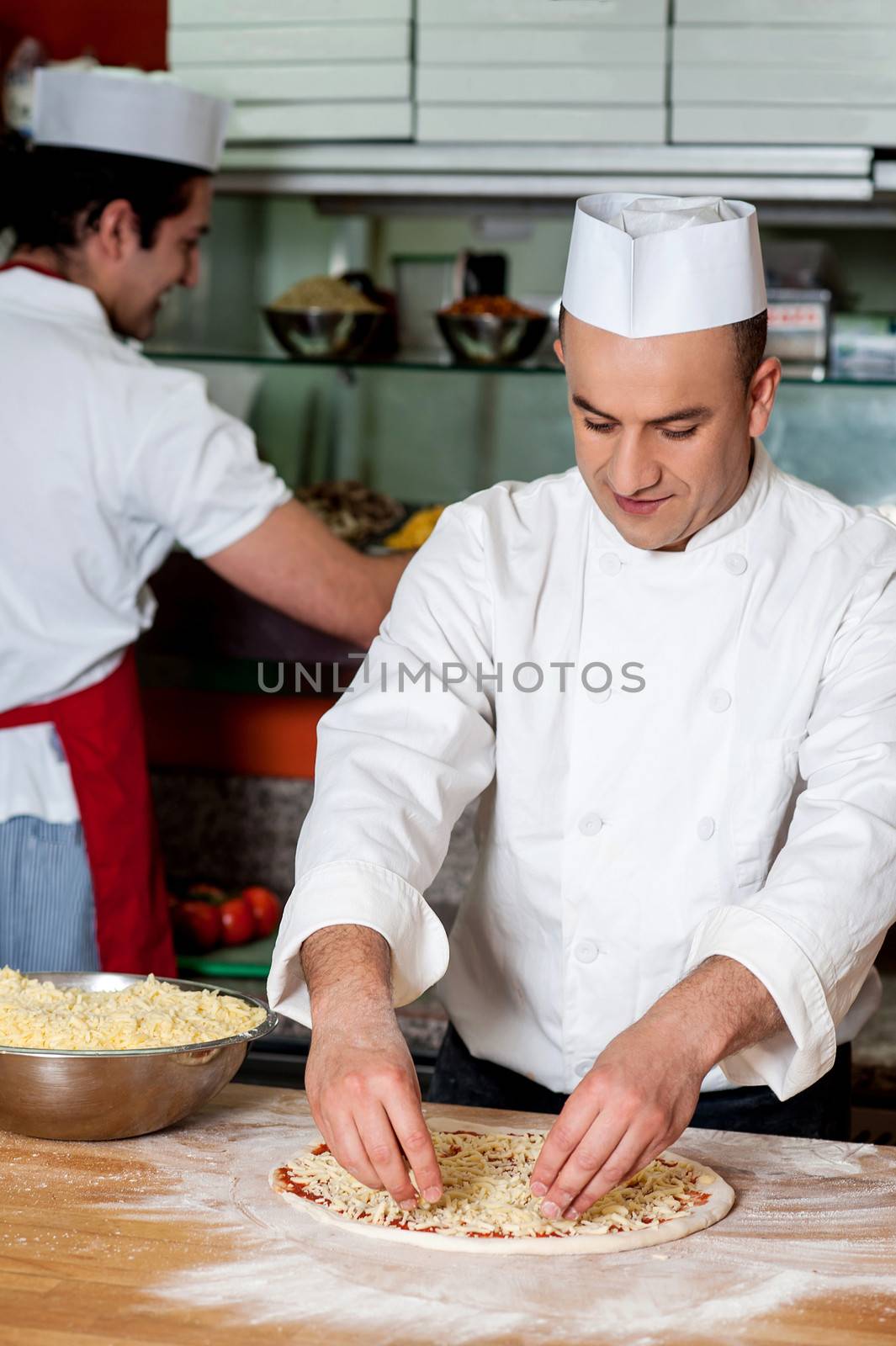 Male chefs working in kitchen by stockyimages