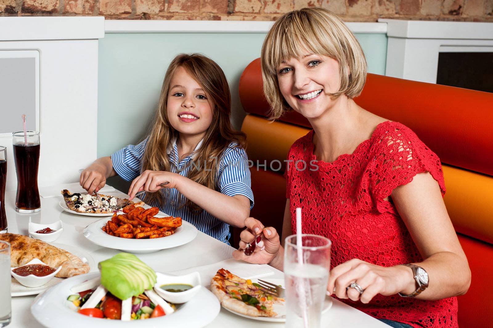 Mother and daughter enjoying meal together by stockyimages