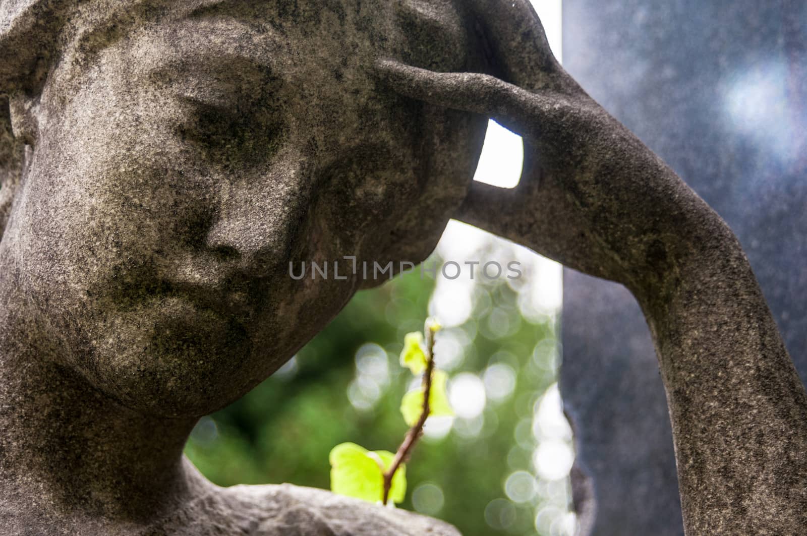 detail of a mourning sculpture on a cemetery