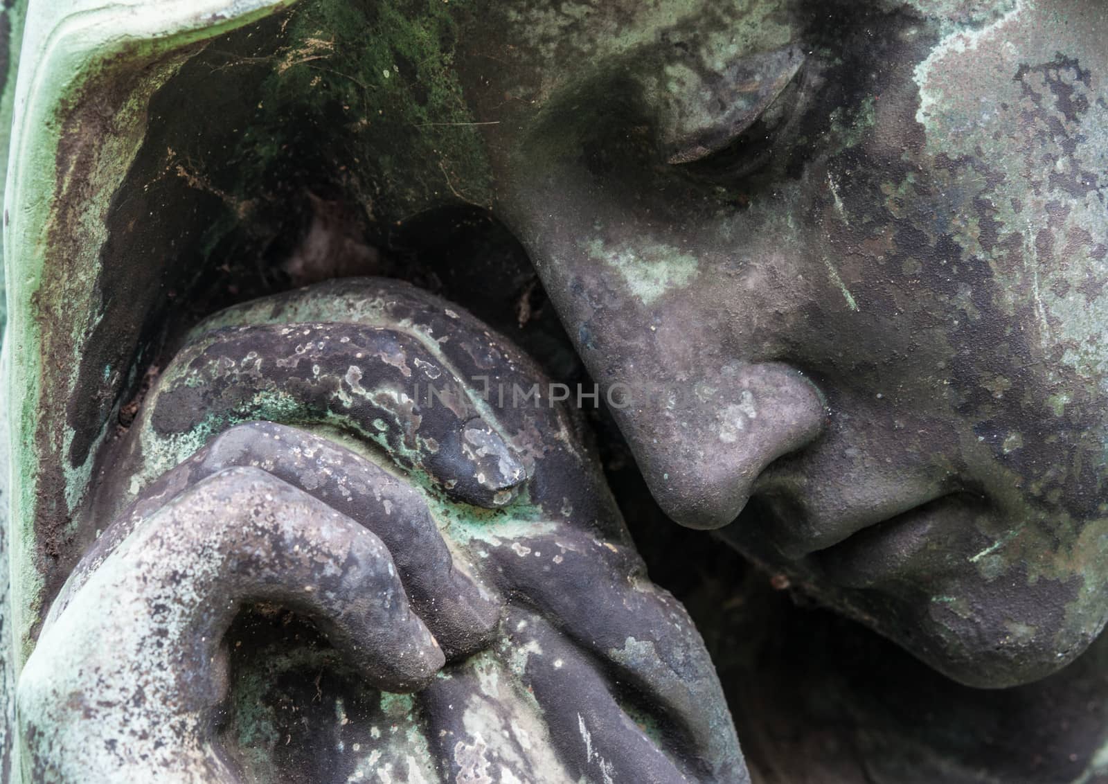 detail of a mourning sculpture on a cemetery