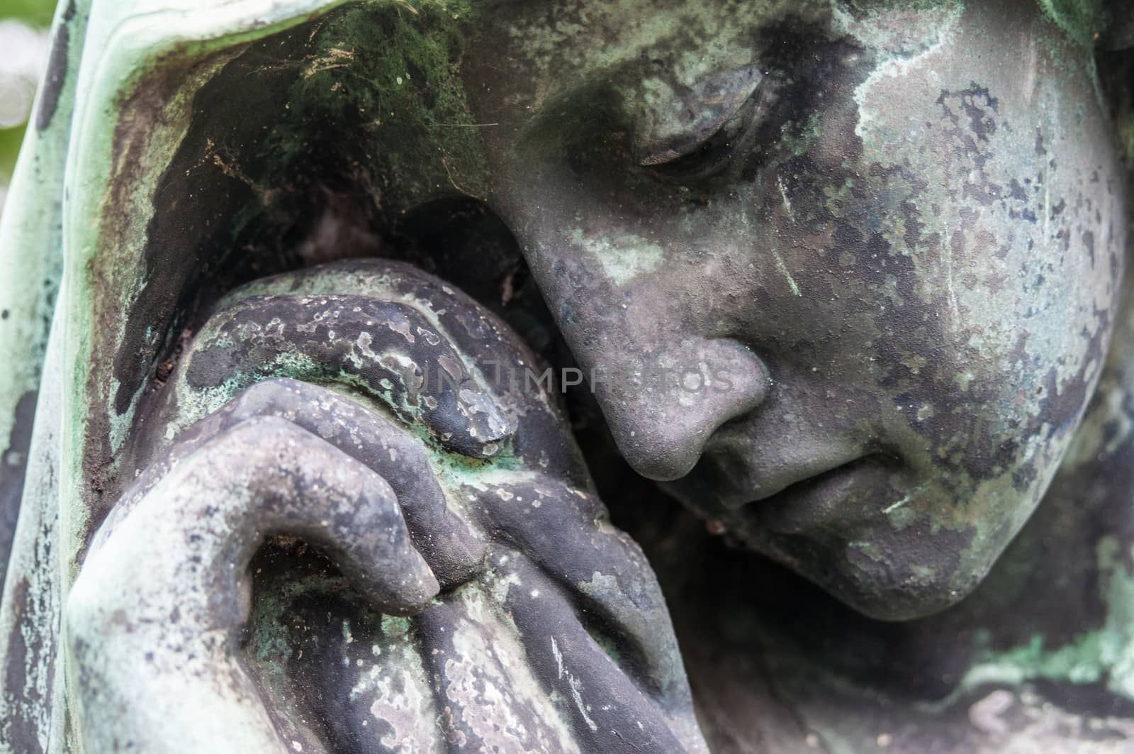 detail of a mourning sculpture on a cemetery