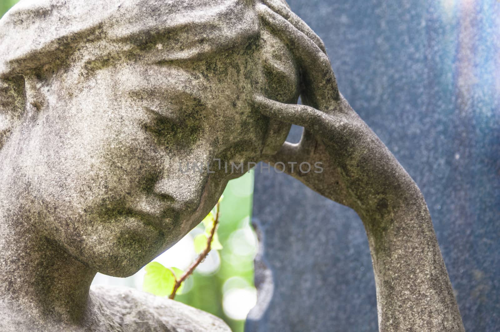 detail of a mourning sculpture on a cemetery