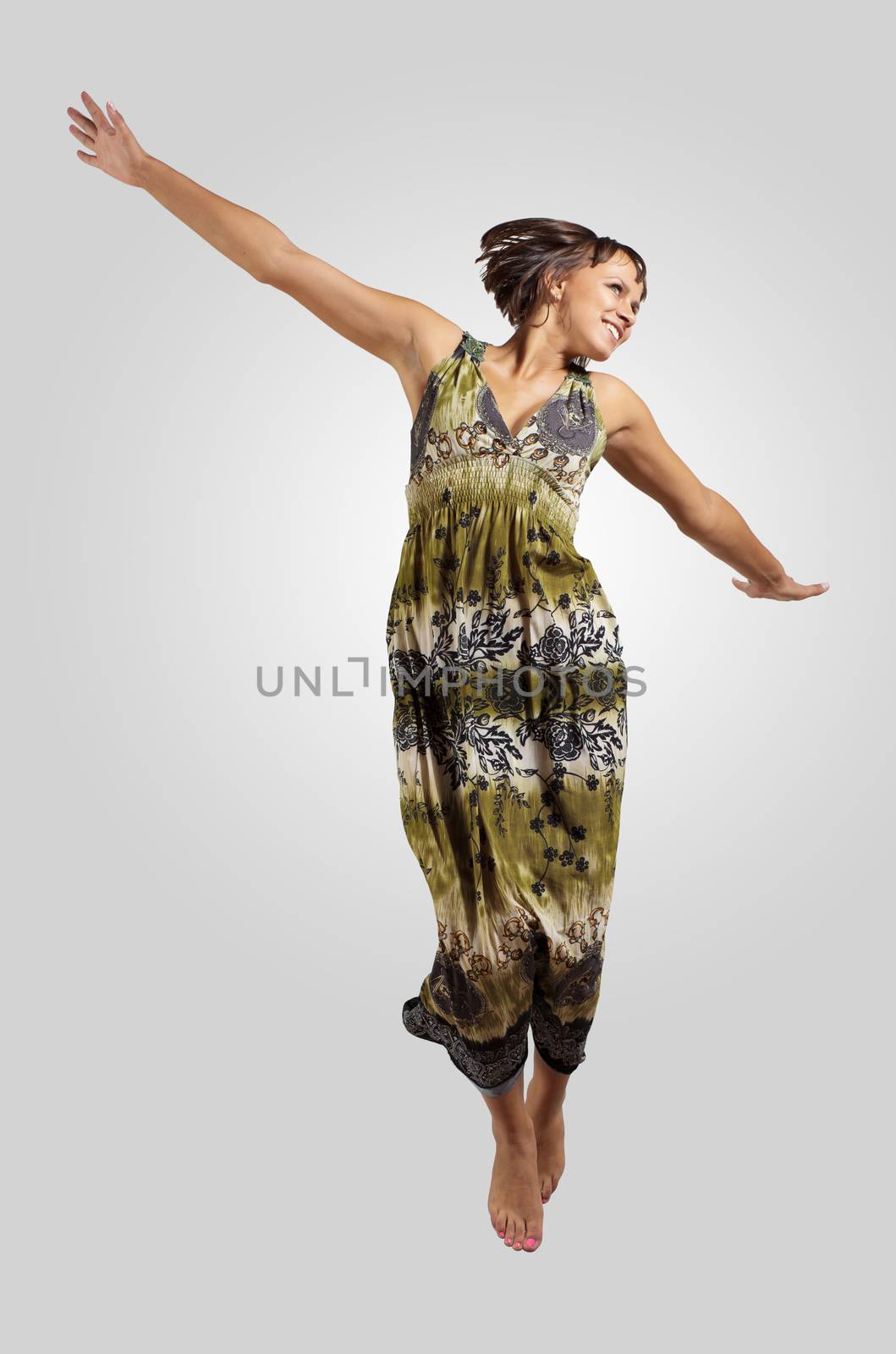 pretty modern slim hip-hop style woman jumping dancing on a grey background