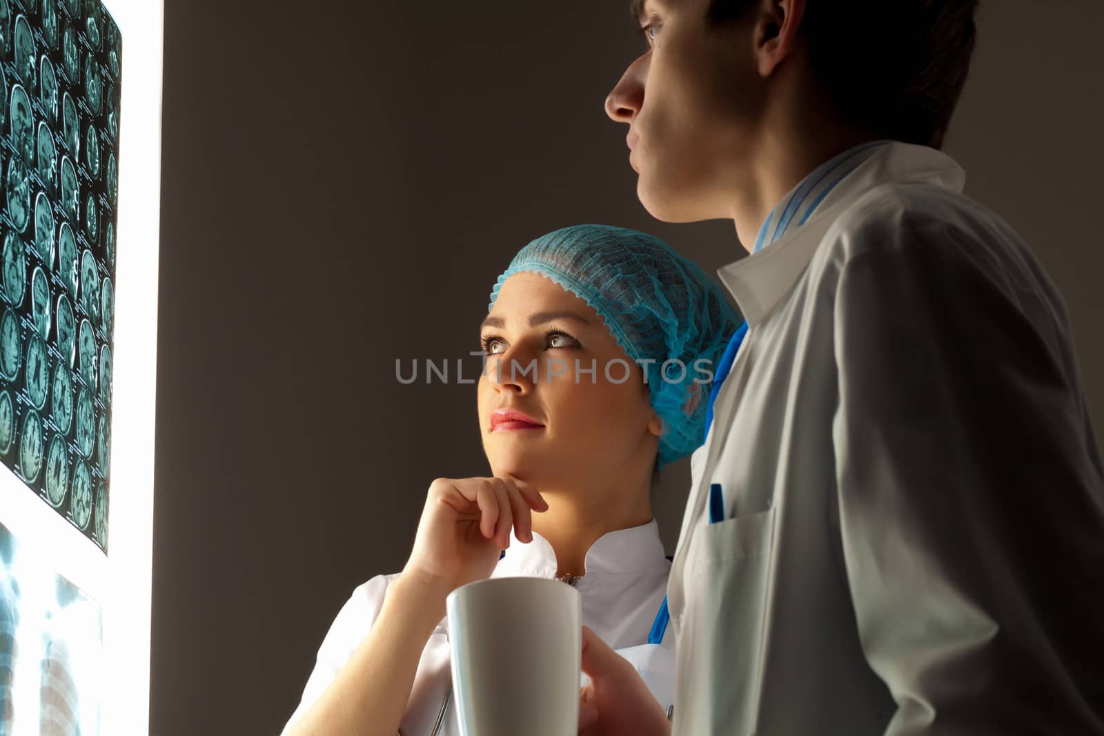 Image of two young two doctors discussing x-ray results