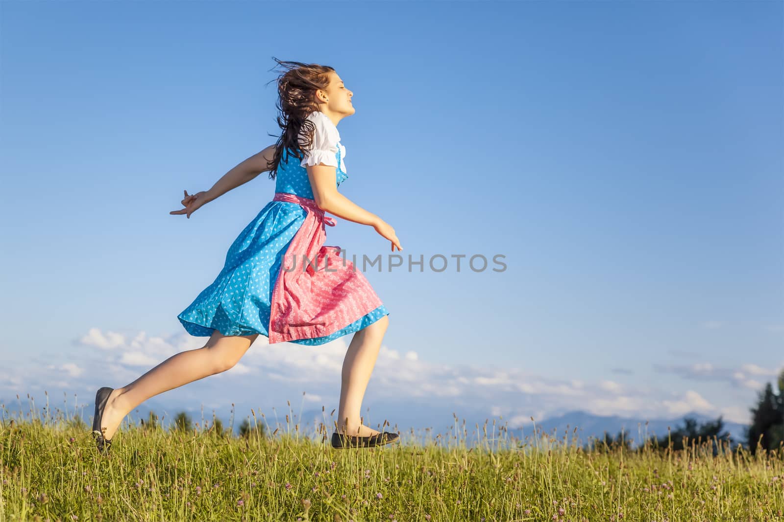 A woman in bavarian traditional dirndl in the nature