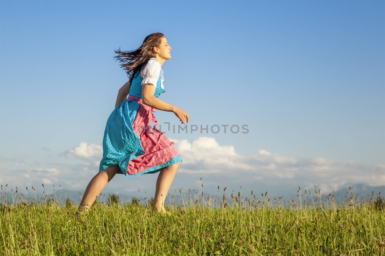 A woman in bavarian traditional dirndl in the nature