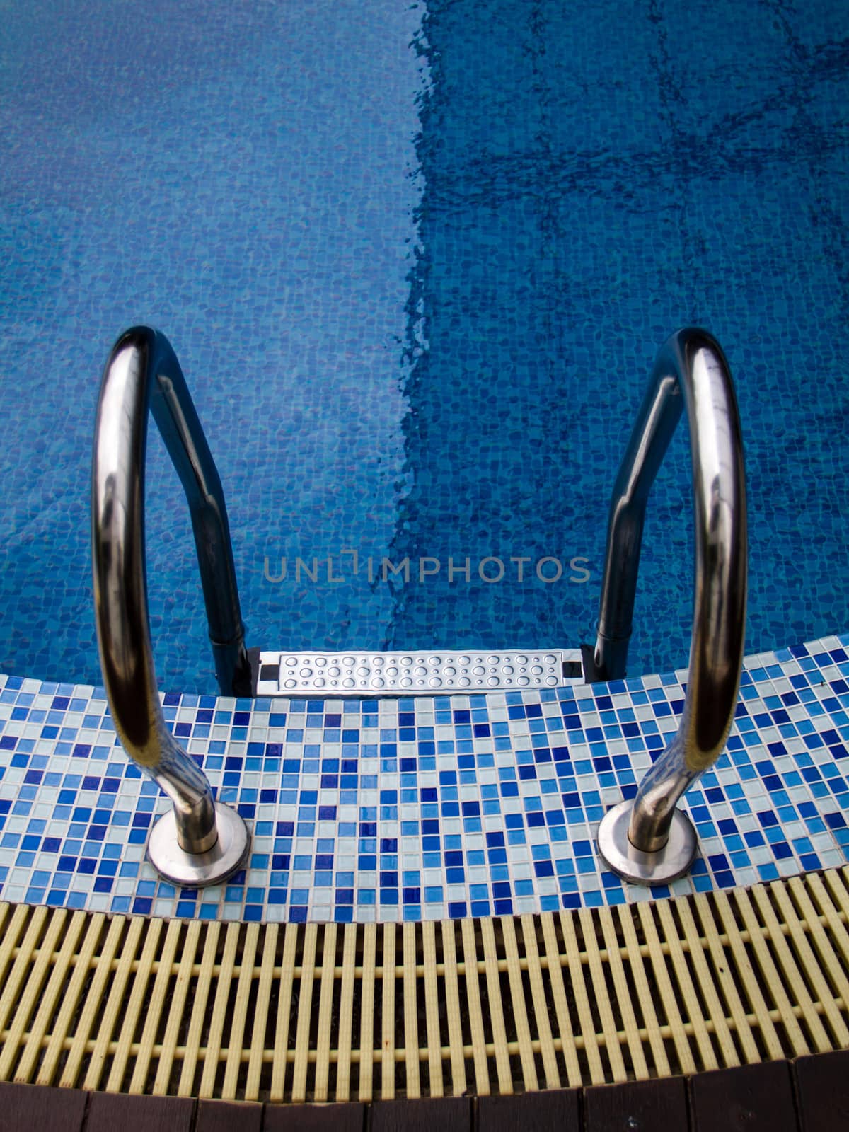 Grab bars ladder in blue swimming pool