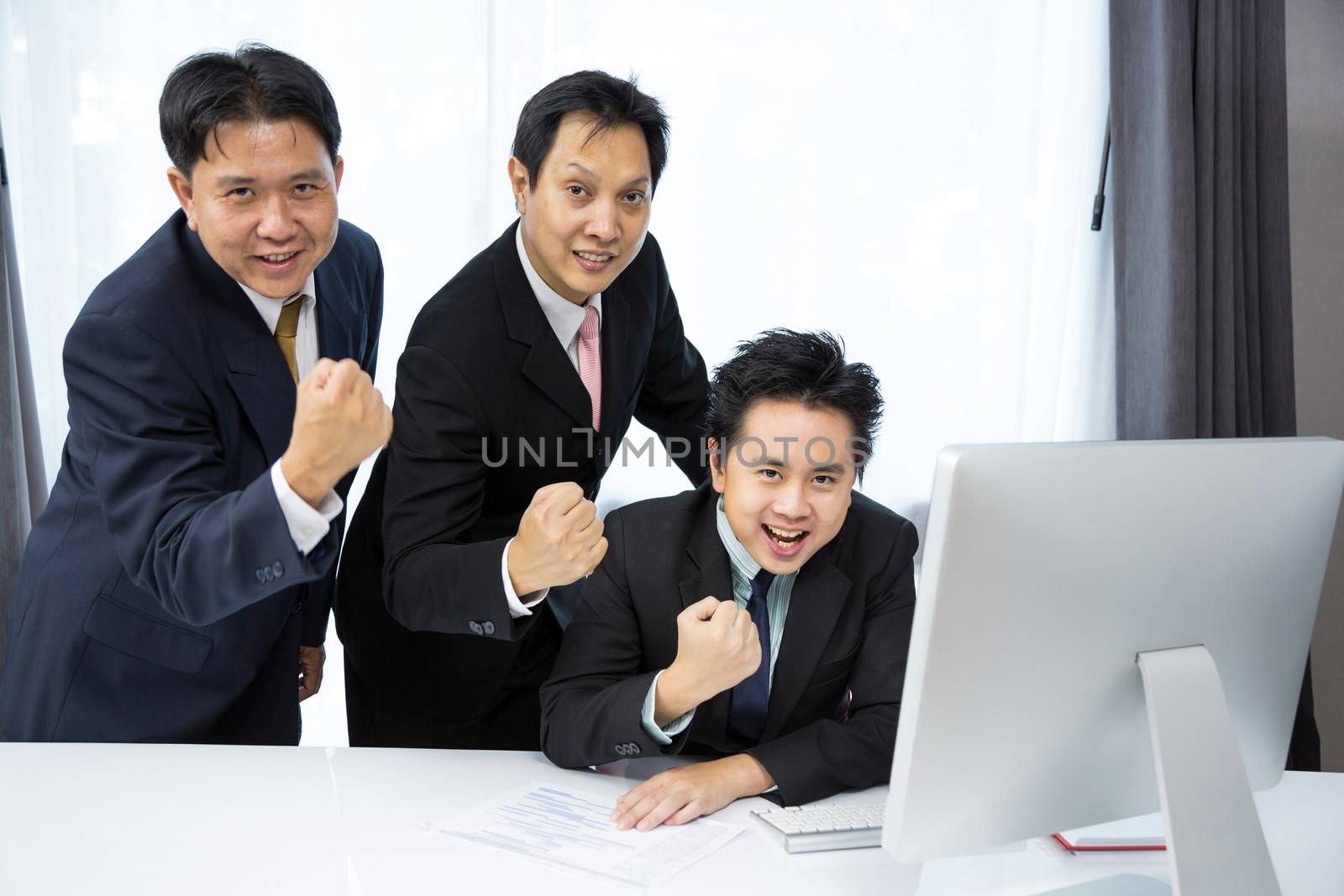 Team of businessmen analysis their business with computer desktop