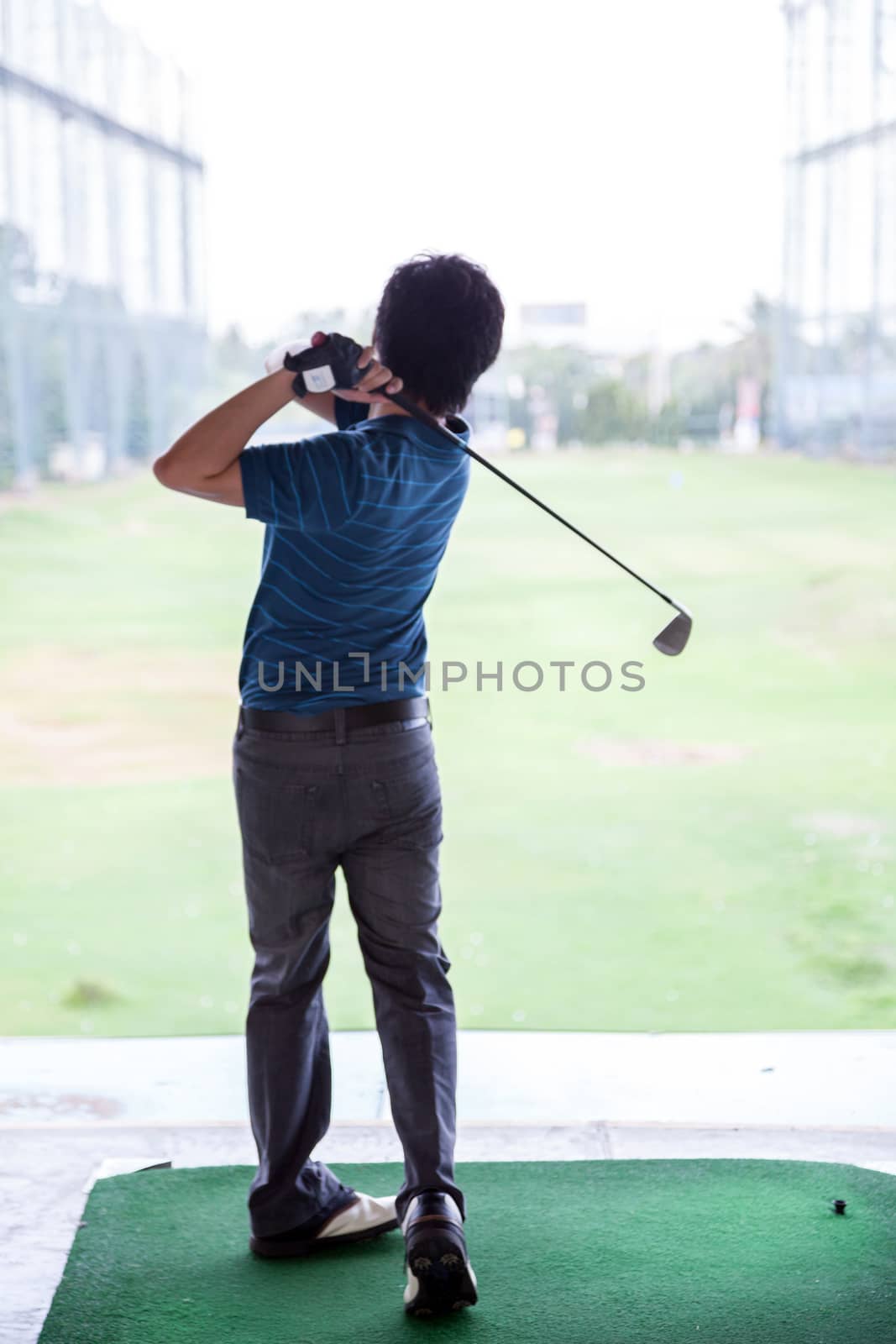Young male golfer practicing his drive