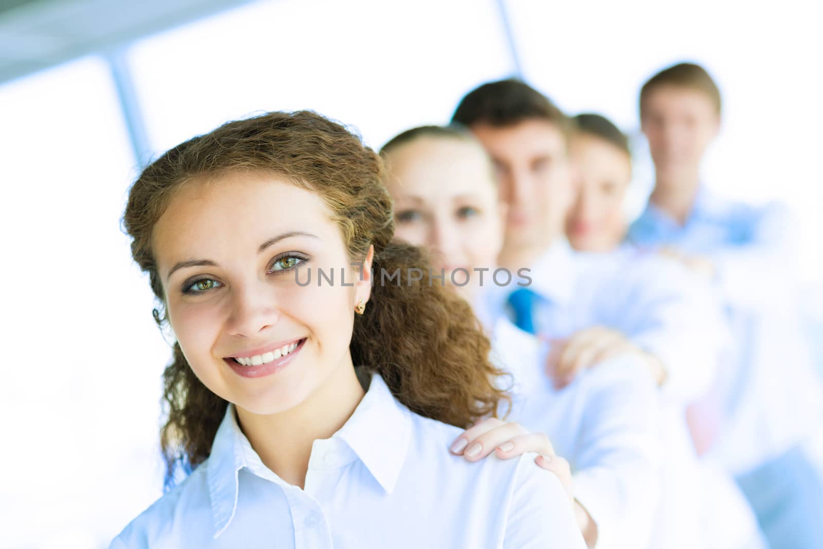 portrait of a young business woman standing in line with colleagues, concept of teamwork