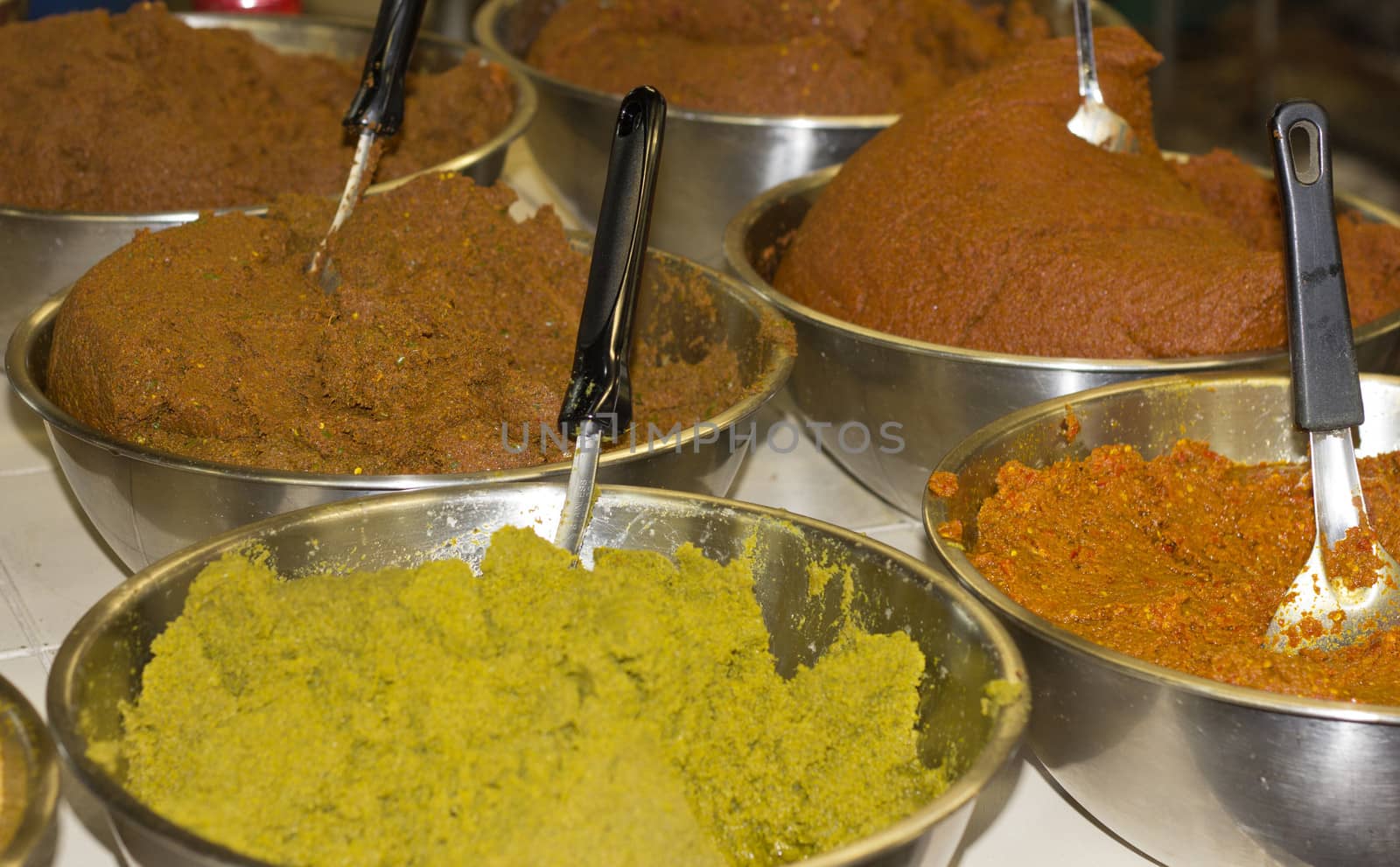 Red and green Thai curry spices for sale in market, Phuket