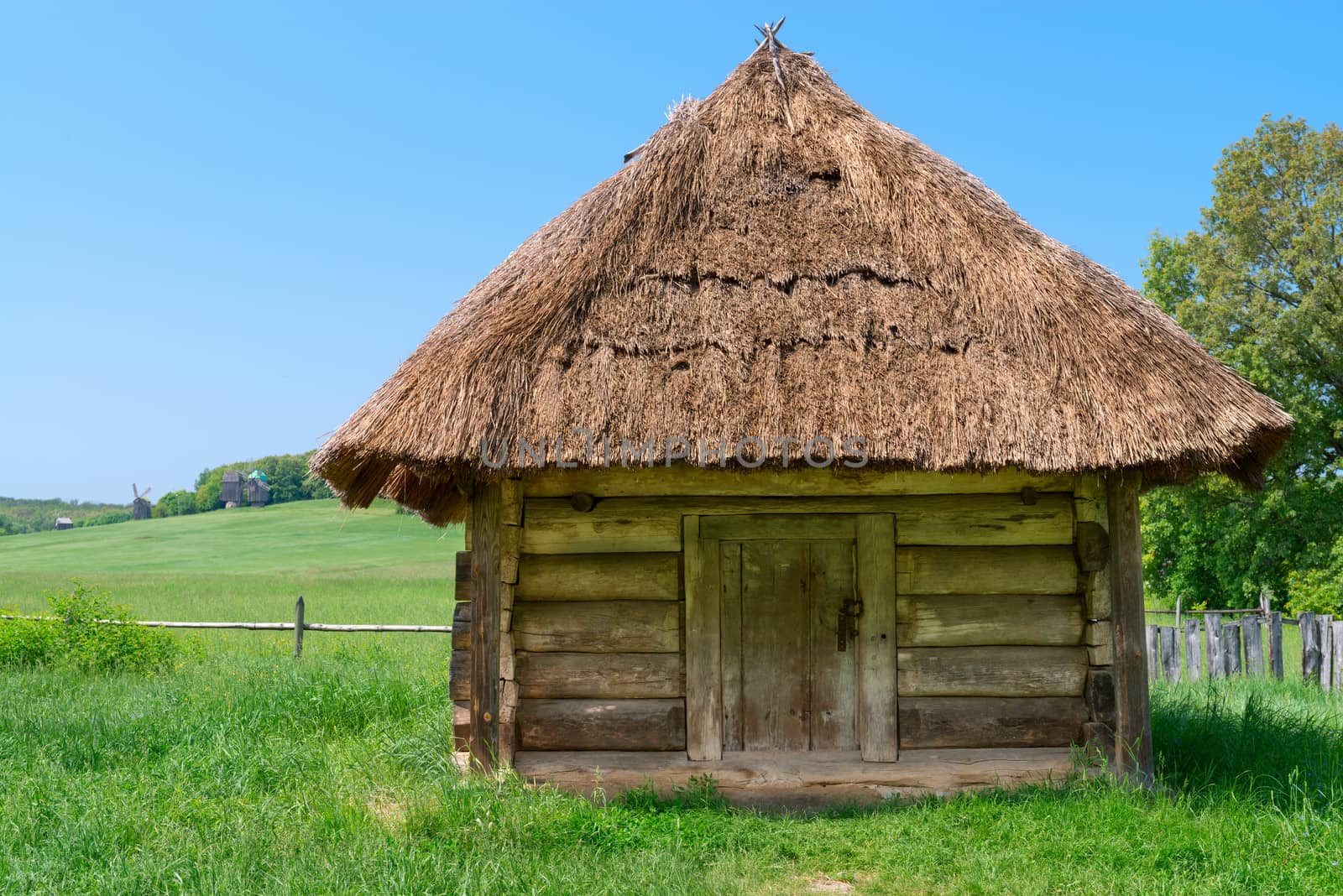 Typical traditional square village antique wooden storehouse or shed with straw roof